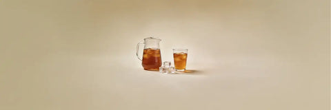 A glass of chilled mugicha barley tea with condensation on a warm day, showcasing its deep amber colour