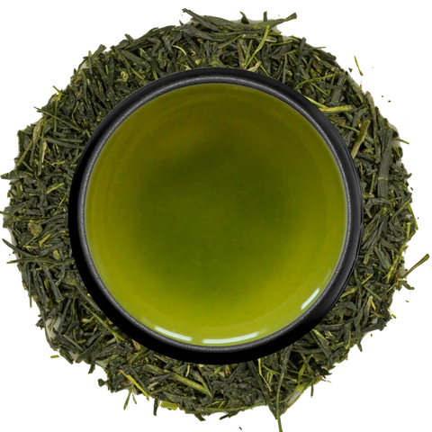 A cup of golden-green sencha seen from above, ringed by needle-shaped sencha leaves on a white background